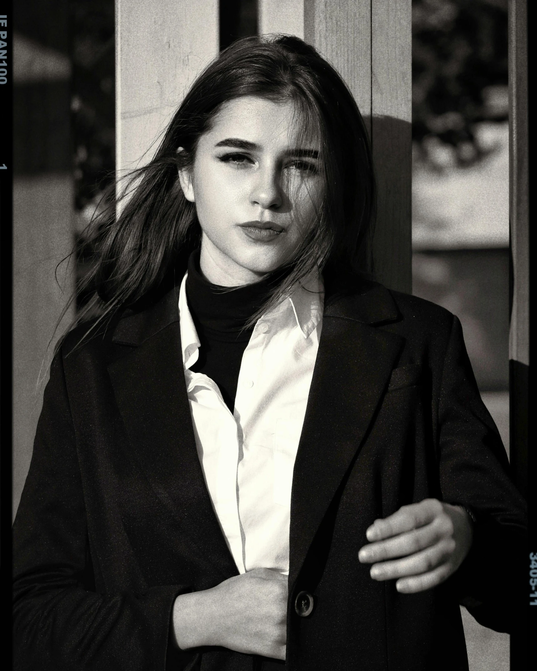 a girl in a business suit holding her hand near her head