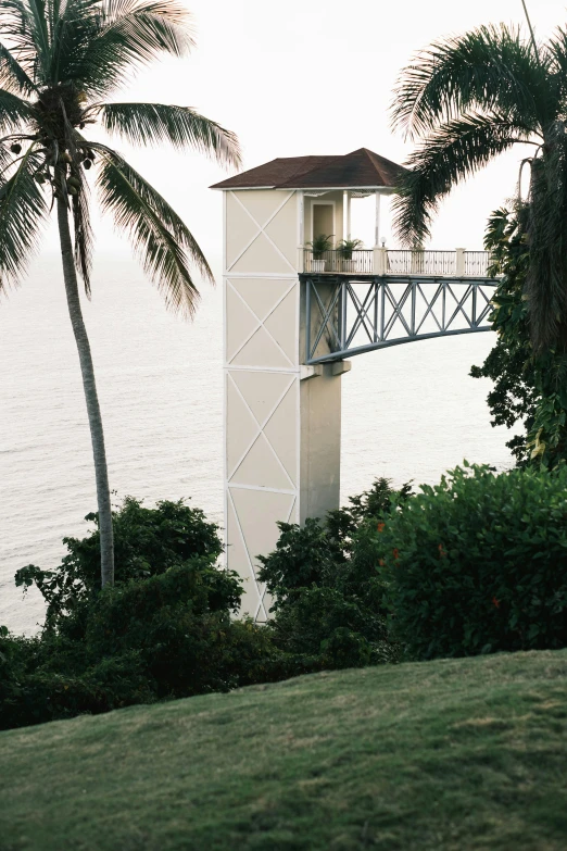 a white tower on the beach with palm trees around