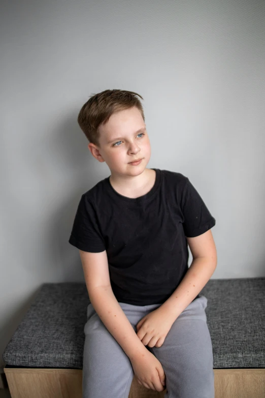 a little boy sitting on a wooden bench