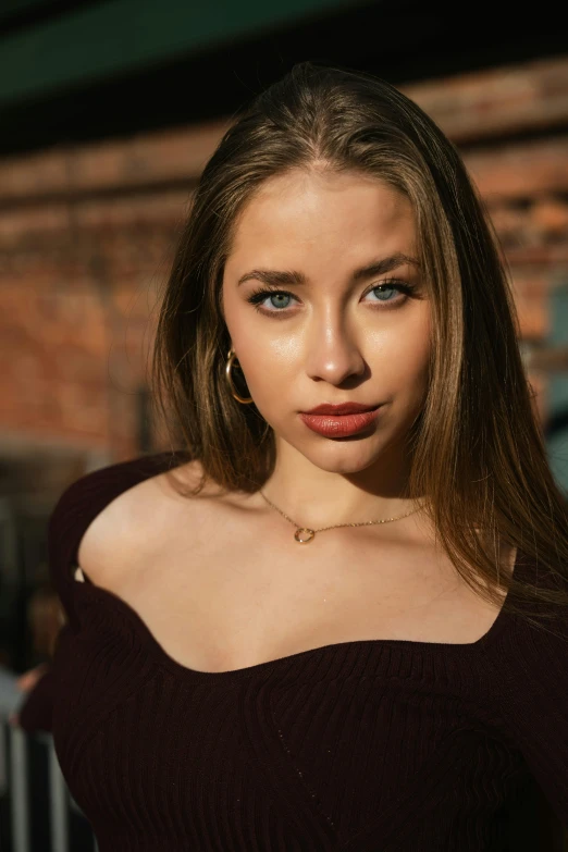 a woman in brown sweater holding up a chain