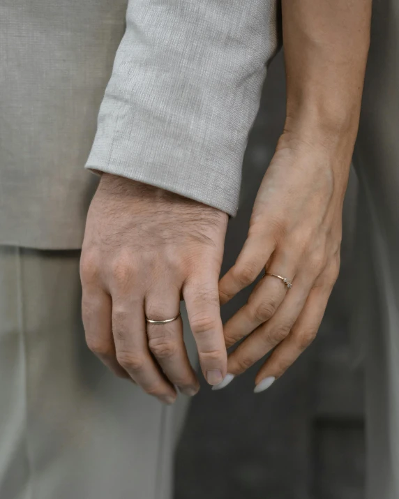 an older couple holding hands, one in gold and the other in silver