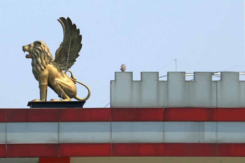 a statue of a lion is on the roof of a building