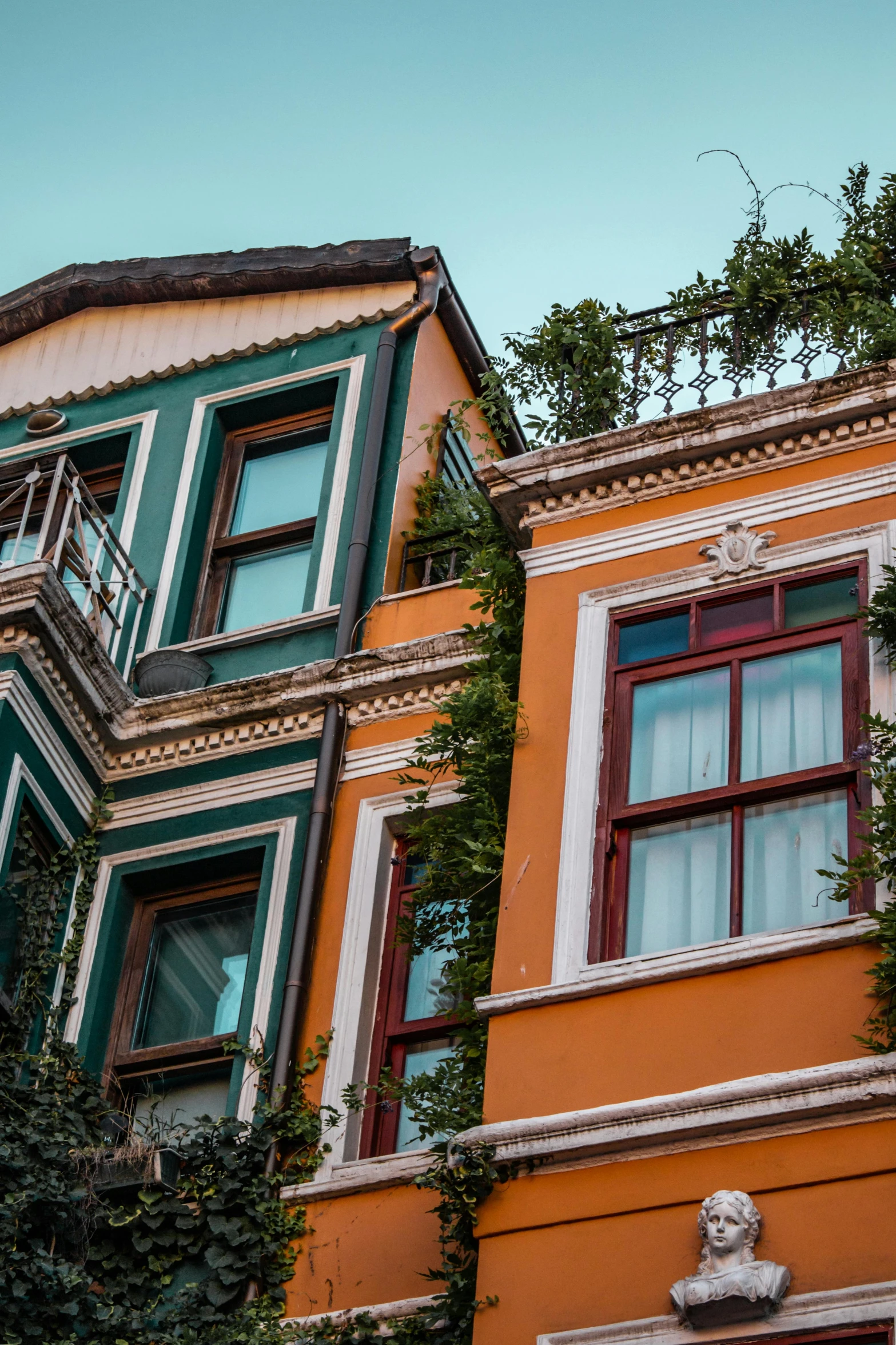 several different color houses with the windows painted orange and white