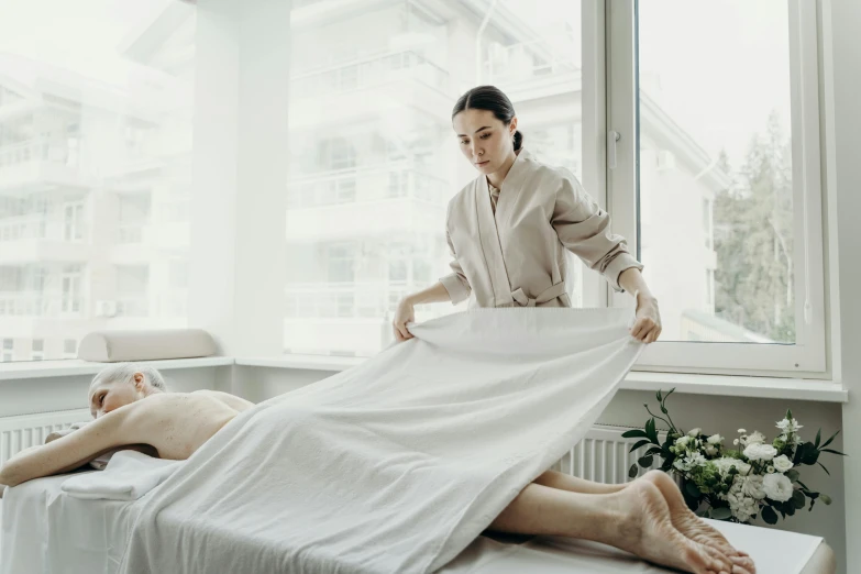 a woman getting a massage by her feet while being covered