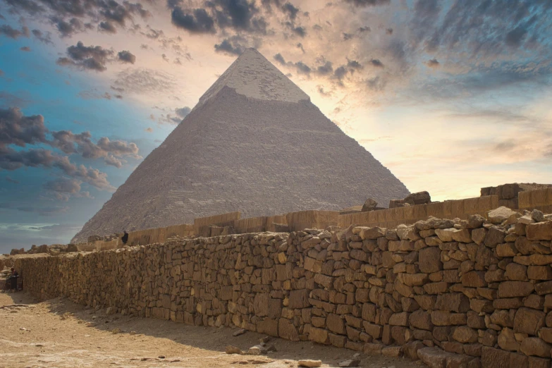 the great sphinx with stone walls, in front of the pyramid