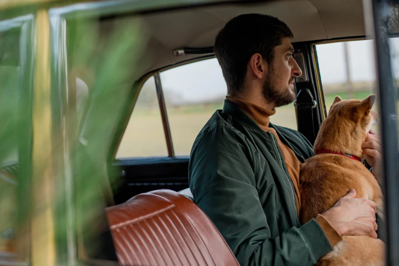 man sitting in the back of his old truck with his dog