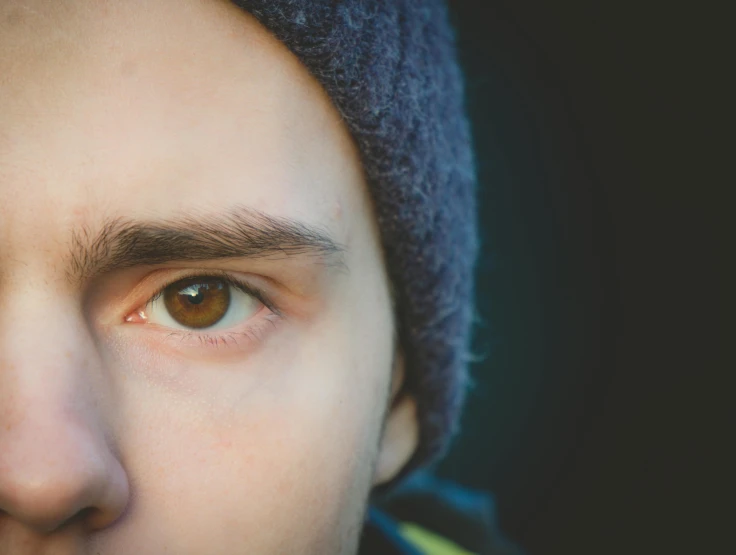 a close - up of a man's eye with a wool cap