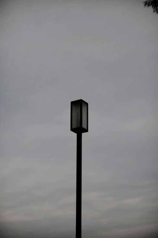 a black and white po of a street light on a cloudy day