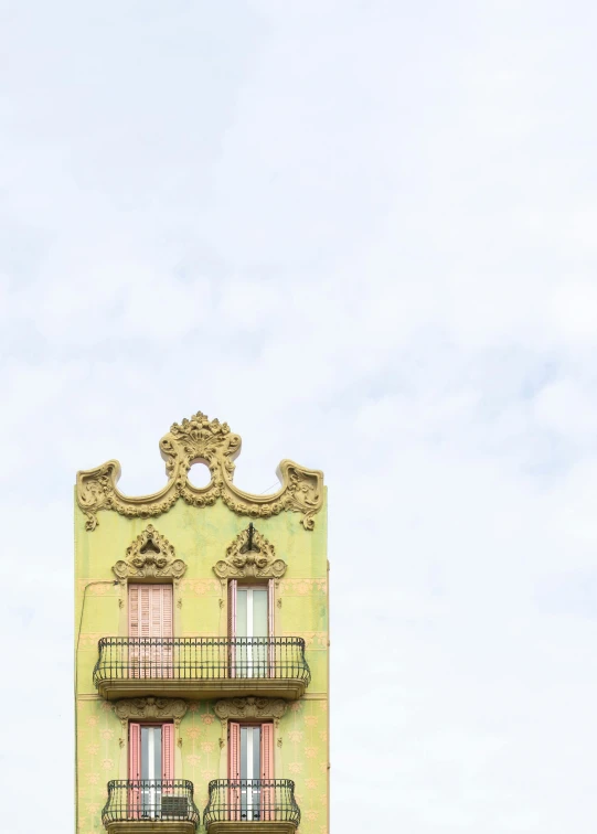 a large green building with two balconies in front of it