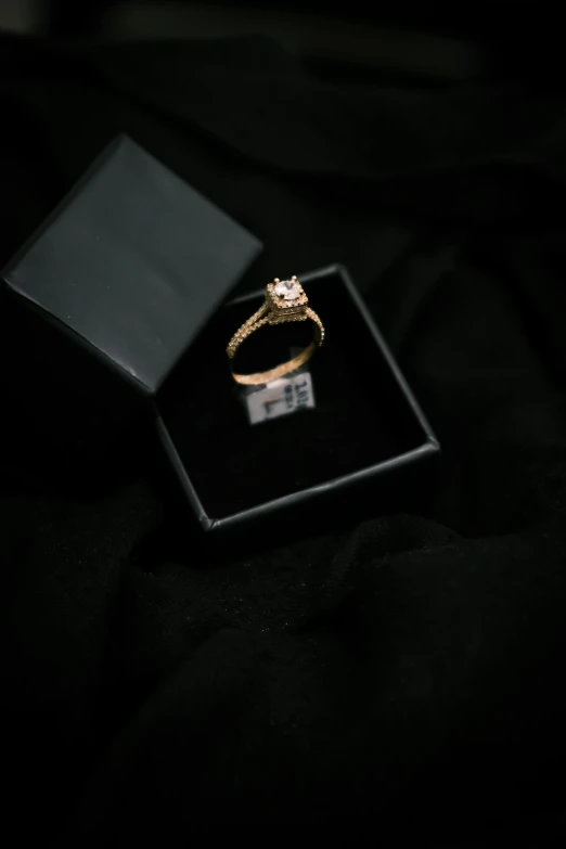 a black square box with a white diamond ring