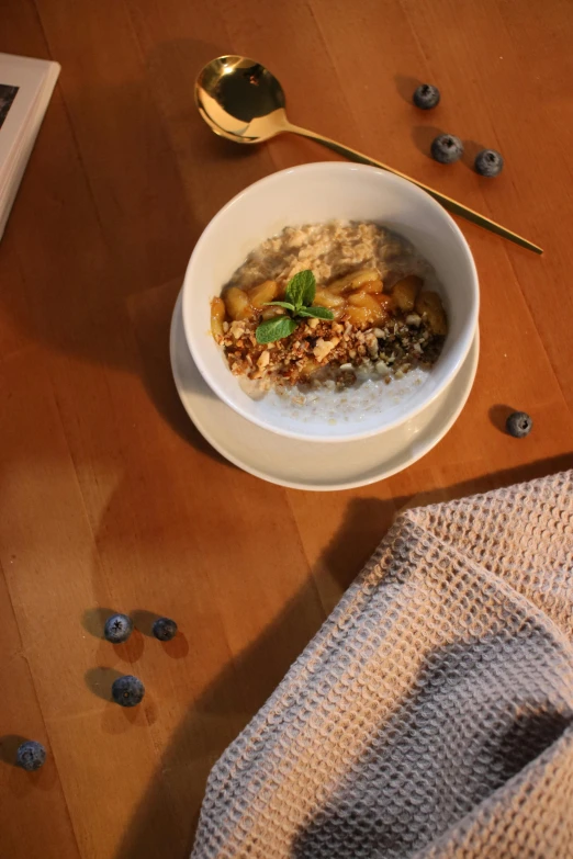 a bowl full of granola sits on a table next to a book