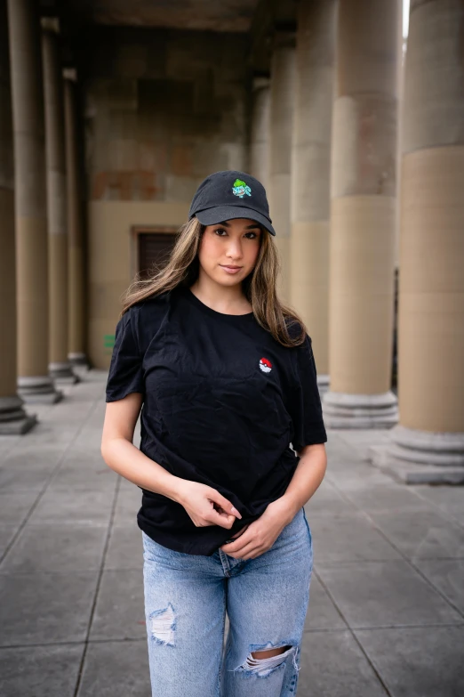 the woman is posing outside near stone pillars