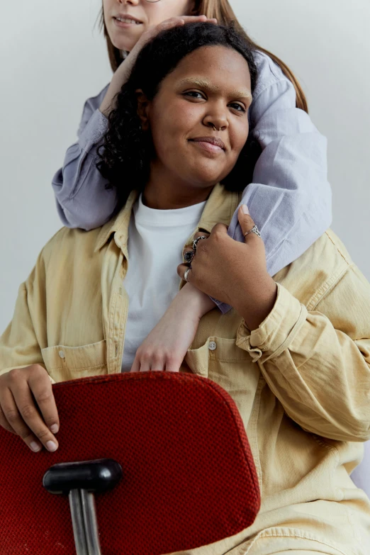 two girls are sitting down holding onto one another