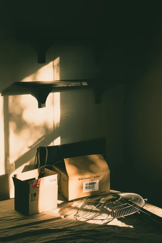 a bedroom with boxes on a table with a shadow