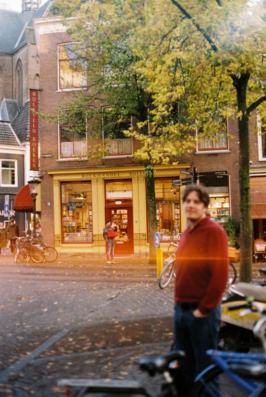 a man standing on the side of a road next to tall buildings