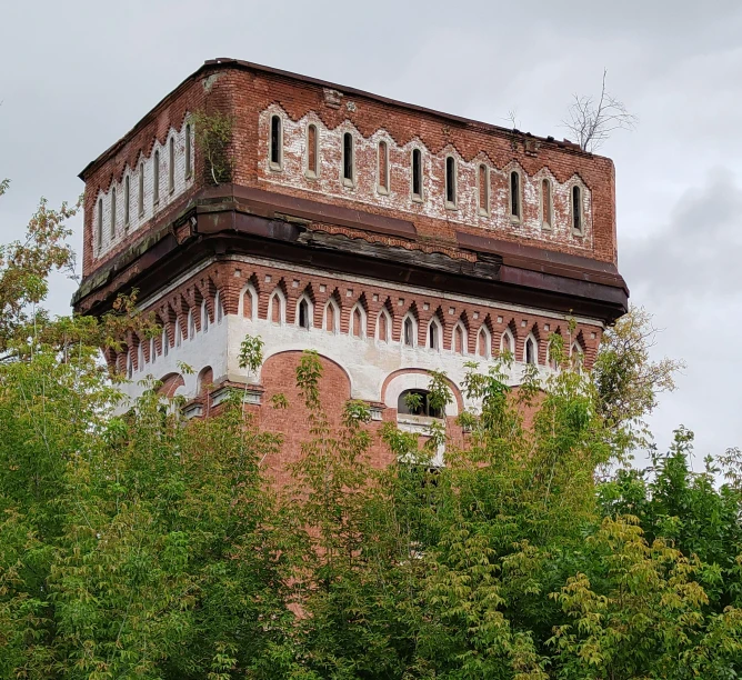 an old building sits behind some green foliage