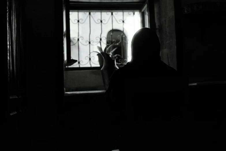 a woman looking through a window in the dark