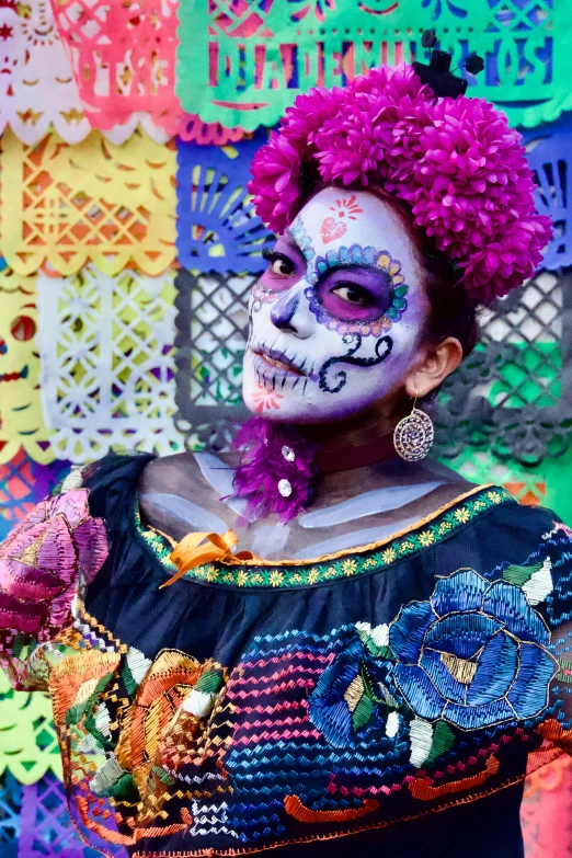 a woman with white makeup and colorful hair, wearing a mexican makeup