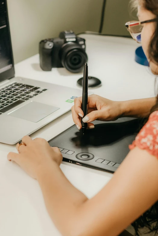 a woman working on an electronic device and doing soing at her desk