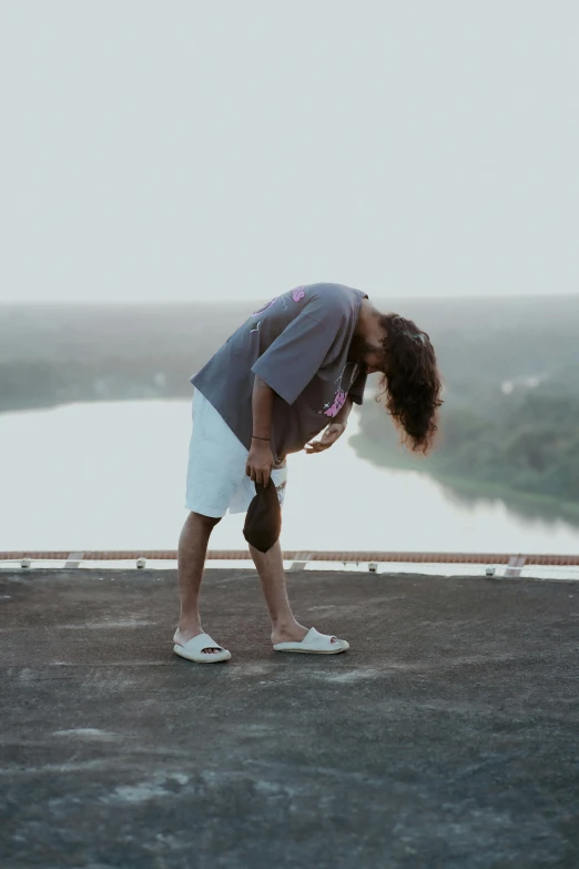 a man is bending down to pick up soing from the ground