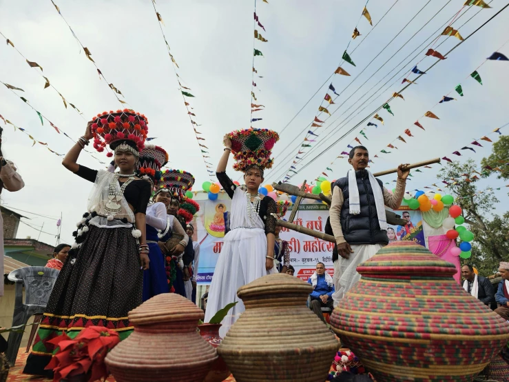 group of people with vases and decorations and banners in background