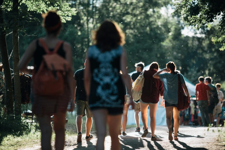 a crowd of people walking through a park