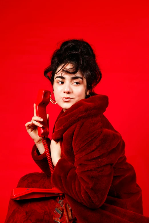 a woman in a red winter outfit holding a phone