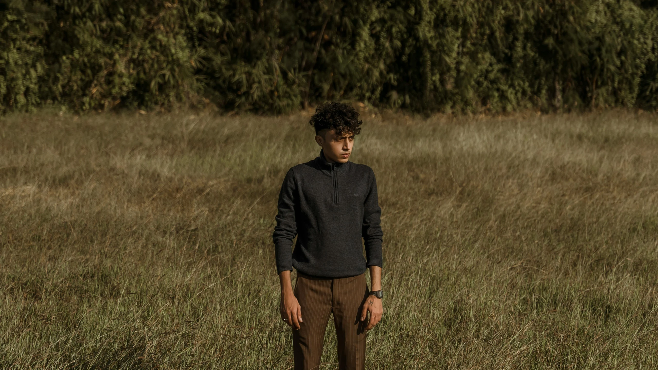 a man standing in a field looking at the camera