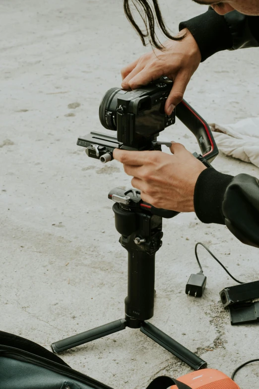 a person holding a tripod in front of camera equipment