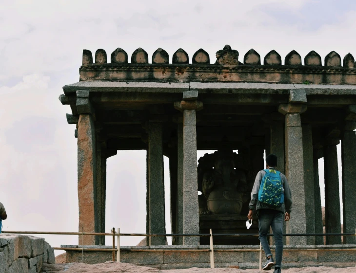 a person walking down a road in front of a large structure