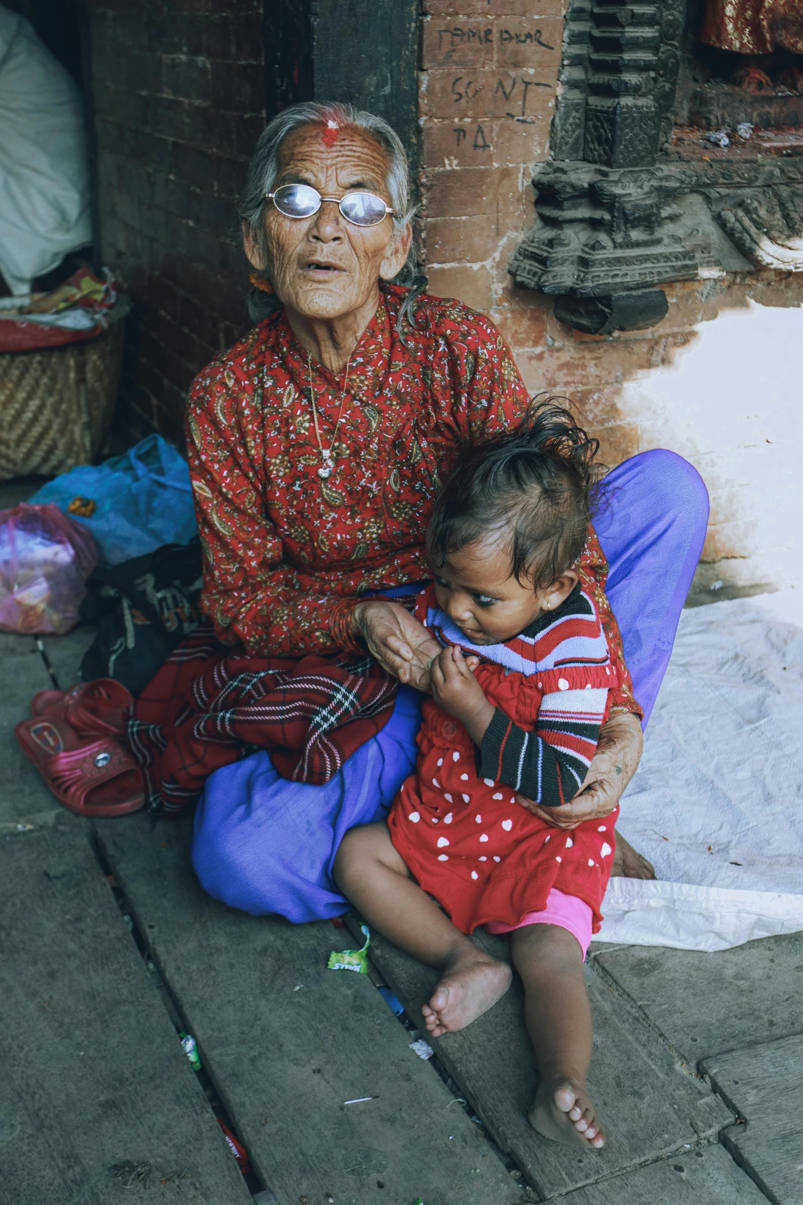 the older woman is holding her child and sitting outside