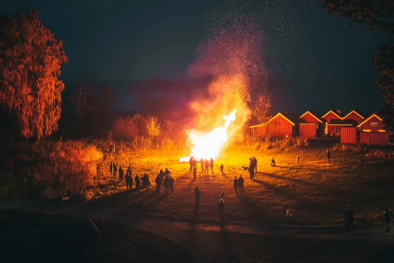 people around the fire in the dark are gathered