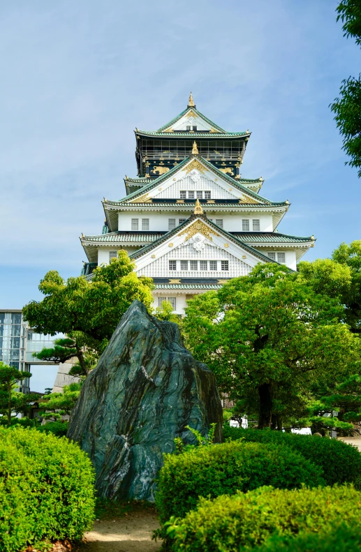 an oriental style building near a park with stone statues