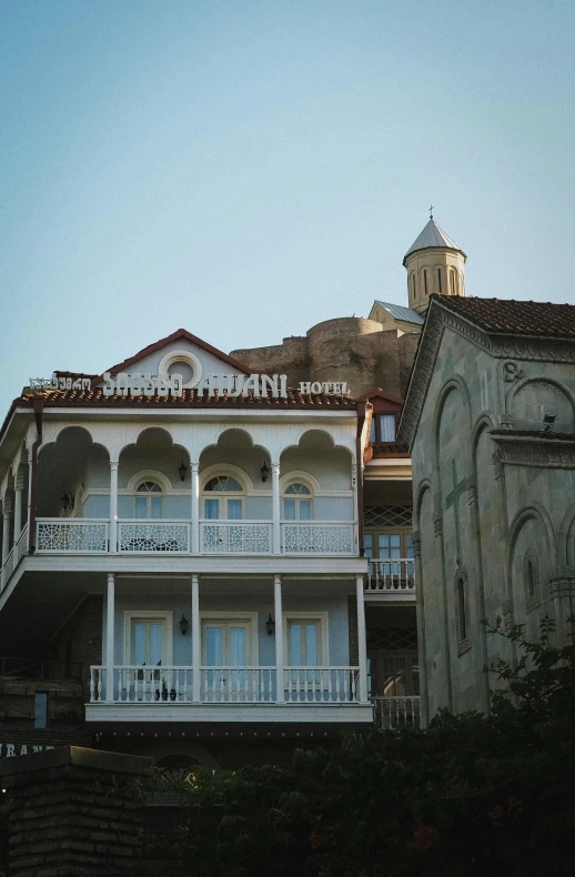 two buildings are standing on both sides of a hill