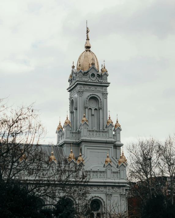 a large white tower with gold roof and spire