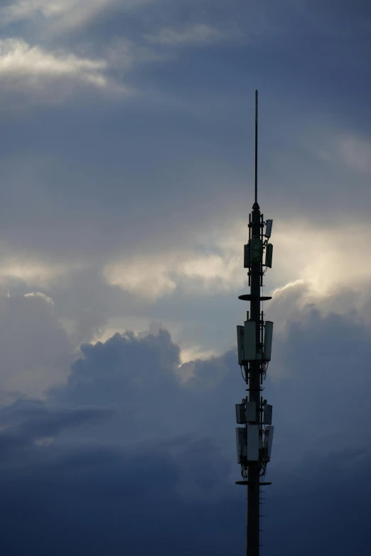 tower with tv stations in it against a blue cloudy sky
