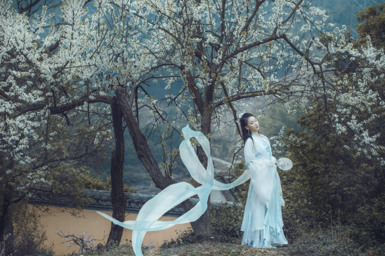 a woman in white and holding a large piece of paper