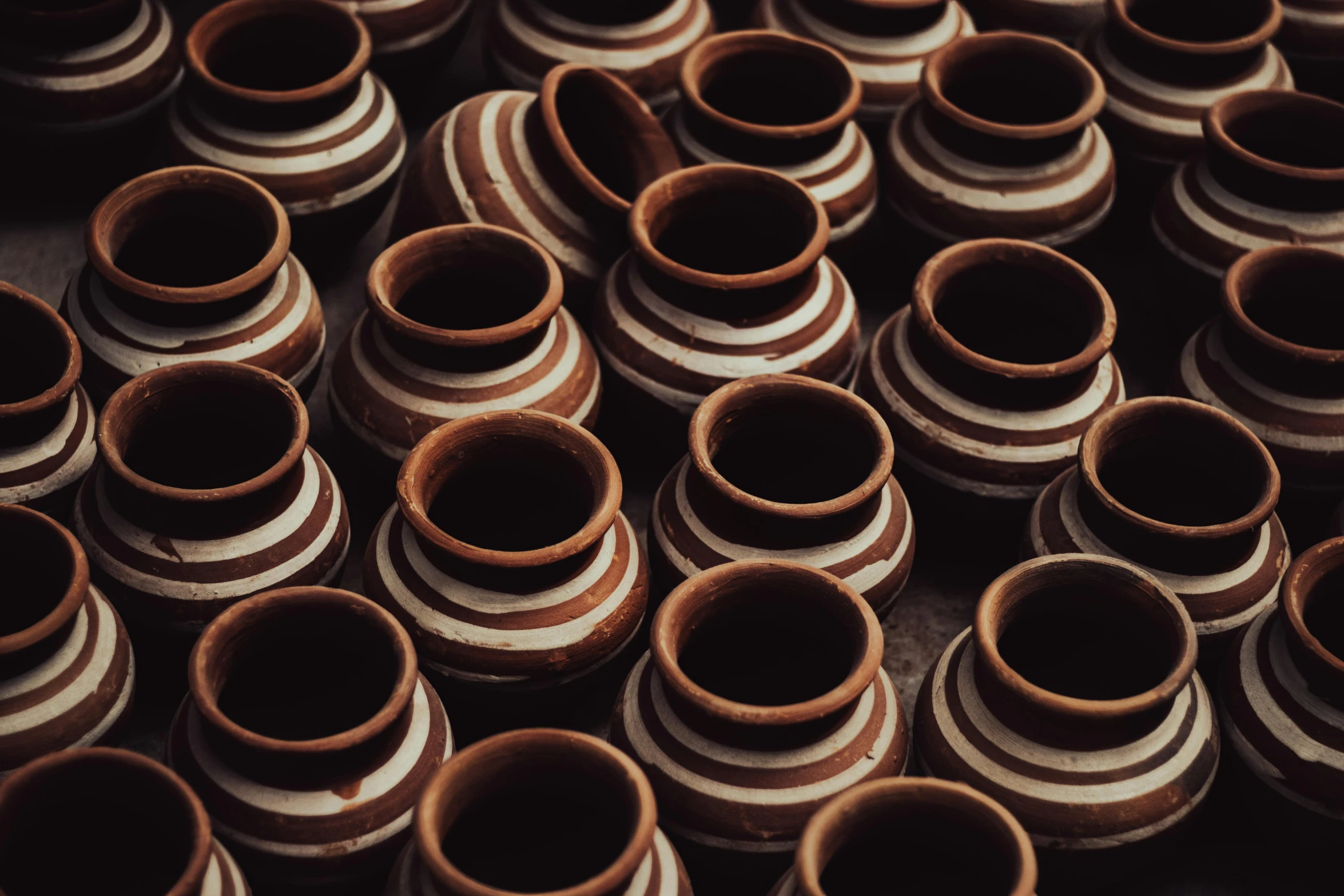 many brown colored vases are stacked up