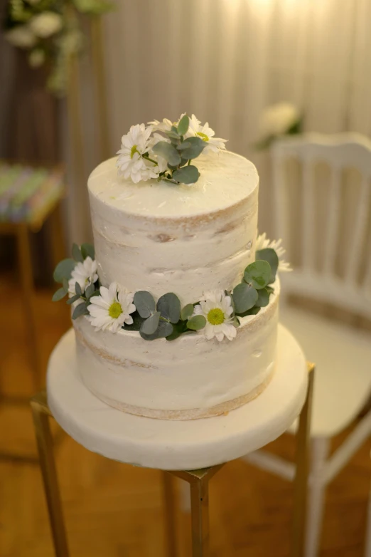 two layers of cake with flowers and greenery on top