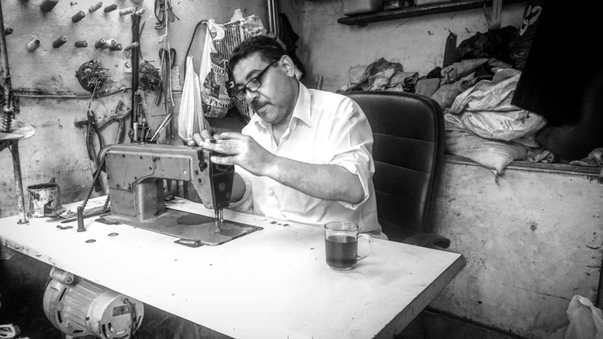 a man is sitting on a sewing machine