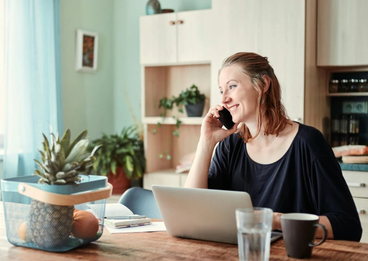 a woman sitting at the table using her laptop