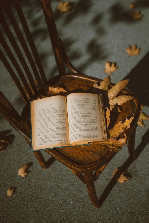 an open book sitting on top of a wooden chair