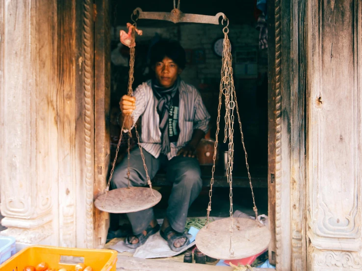 a man is sitting in the doorway while holding a tray