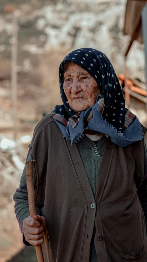 the old woman is standing near many houses