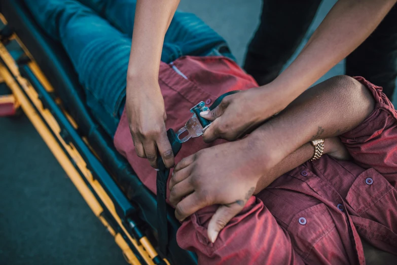 a man sits on the ground with his foot on another person's back