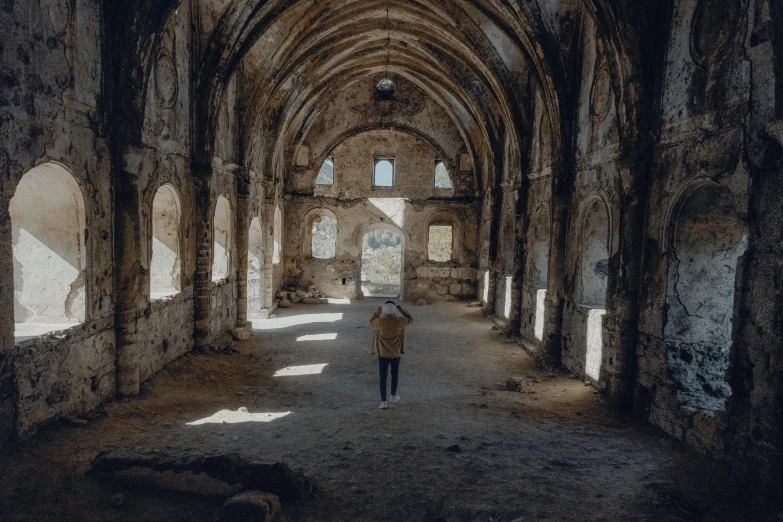 a person standing in a dimly lit hall of stone