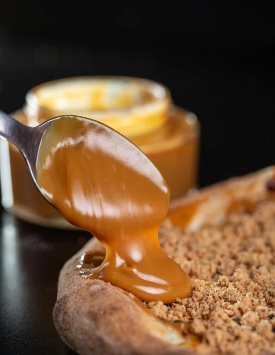 a spoon full of honey on top of bread