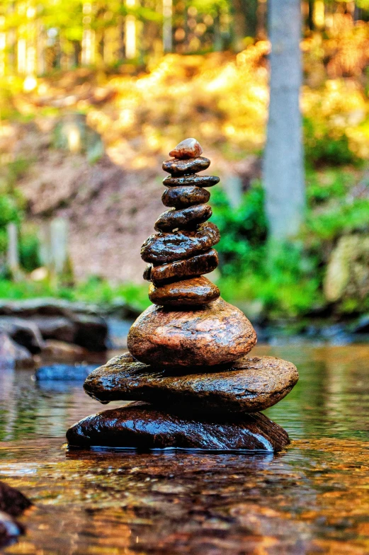 a stack of rocks in a river with water