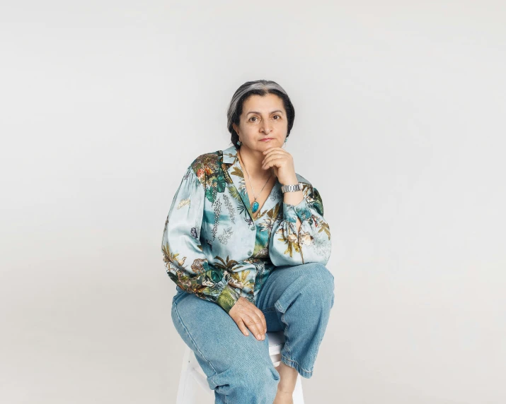 a woman sitting on top of a white stool