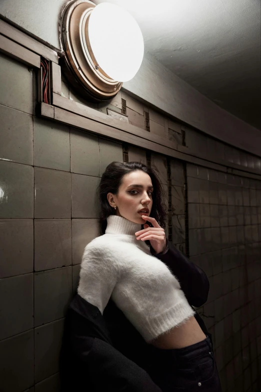 a woman standing in a room next to a wall